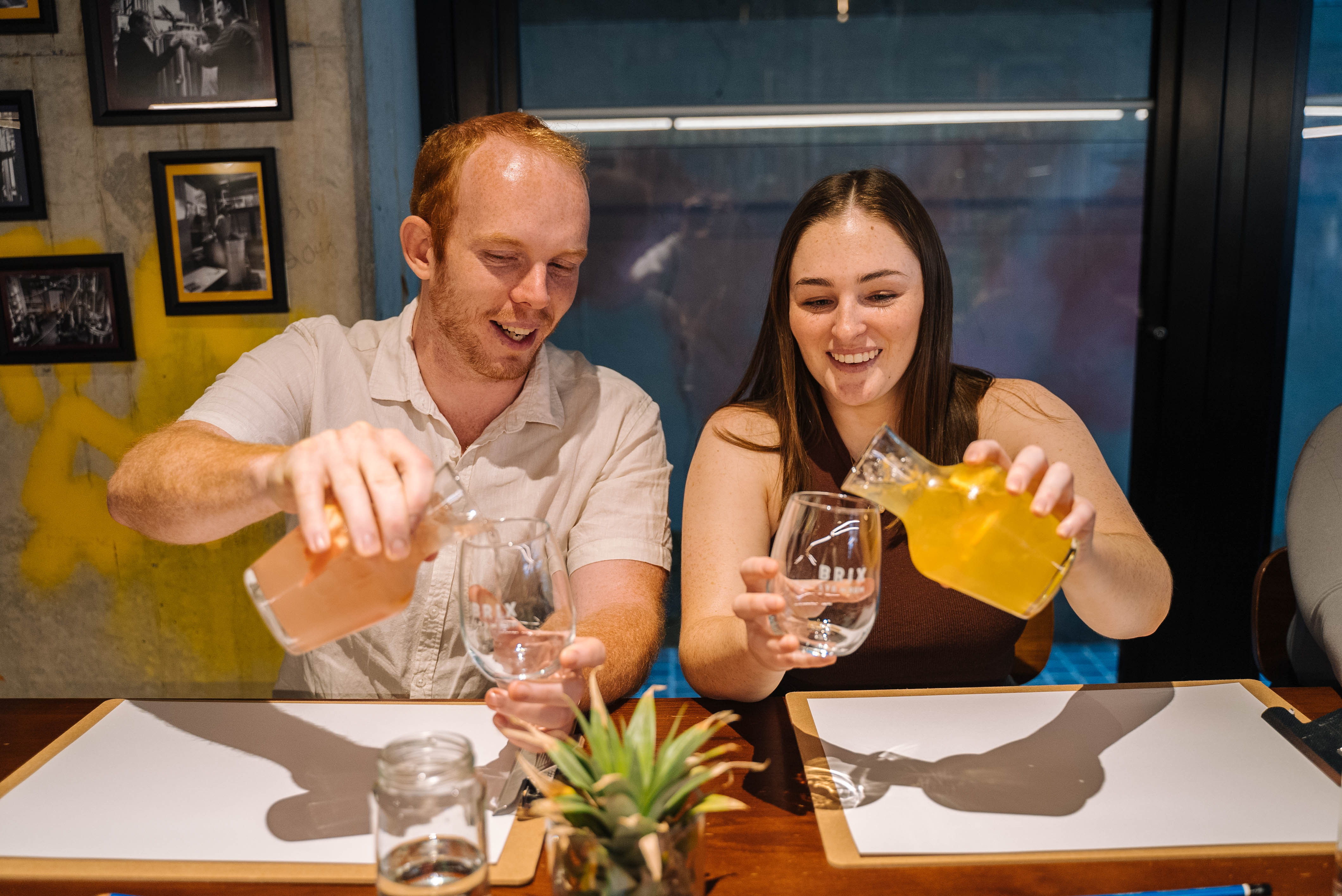 A couple pour cocktails at a paint and sip class